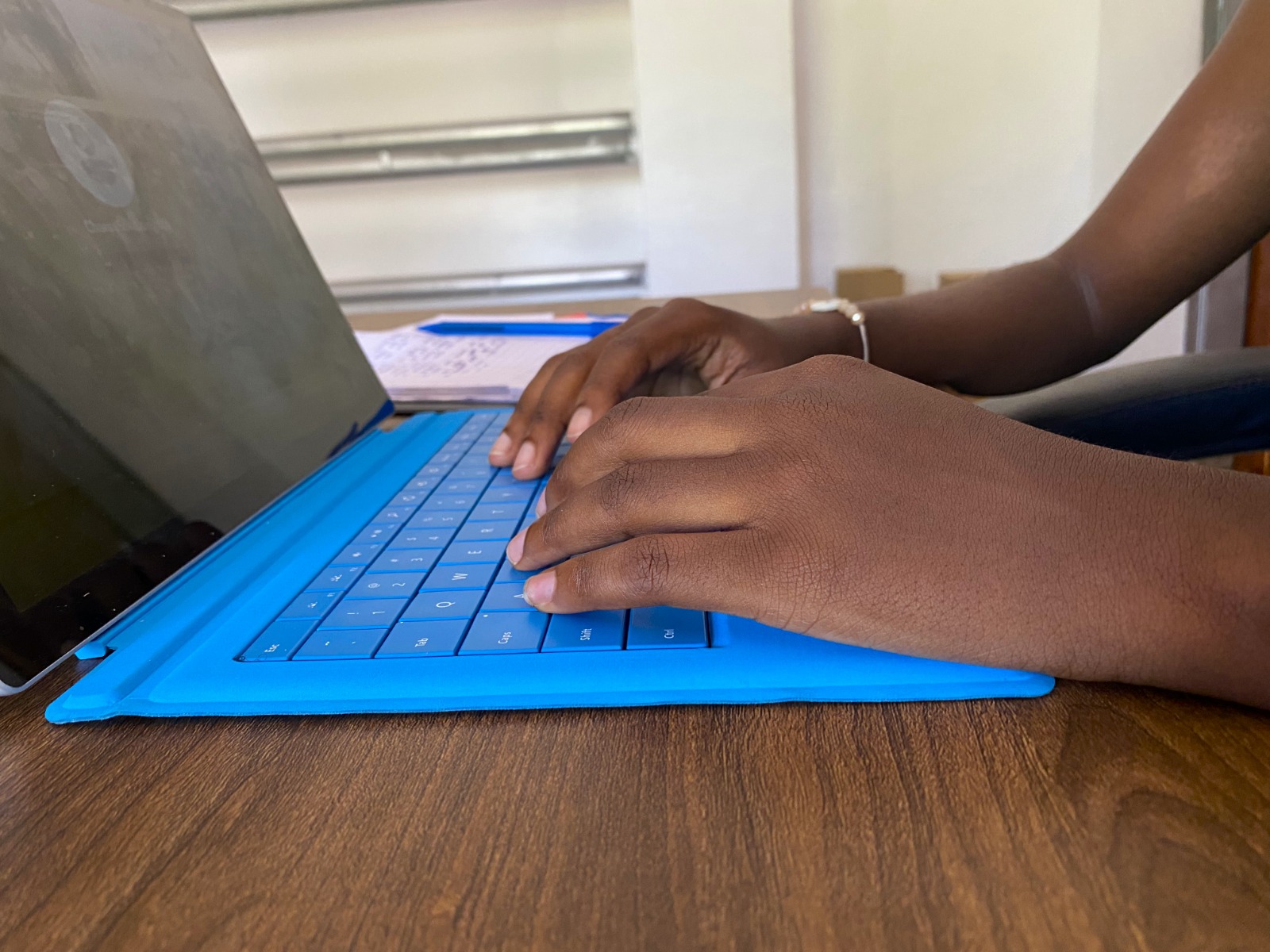 Hands typing on a laptop